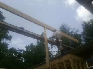 Carpenter setting a ridge beam over a new addition frame — Ice Dam Removal by Roofing Brothers in Andreas