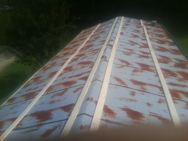 Rusted metal roof panels with new wood purlins before replacement — Storm Damage Roof Repair in Andreas by Roofing Brothers