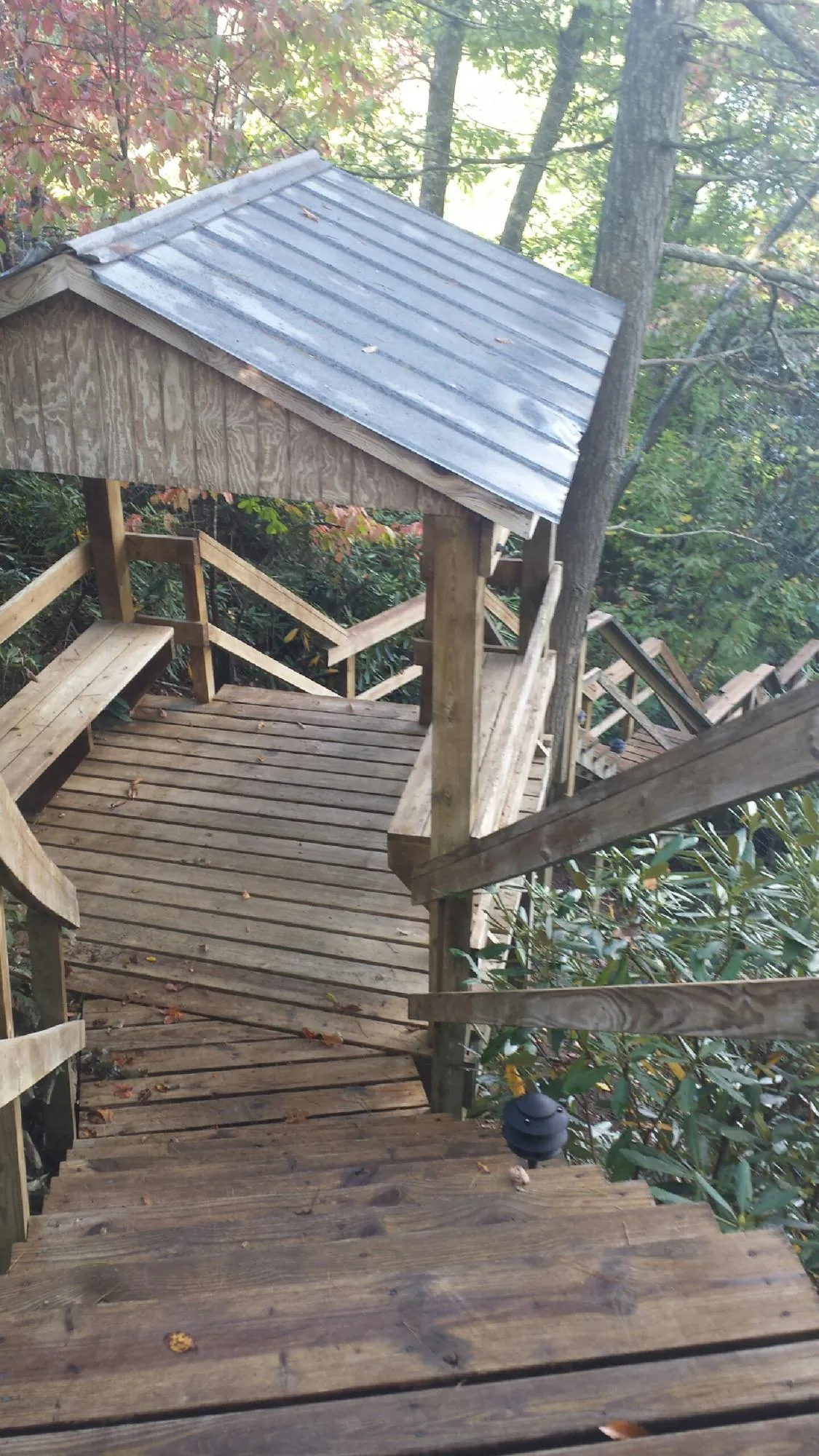 Metal roofed shelter over wooden steps on a wooded walkway — Skylight Repair & Installation work by our crew in Andreas